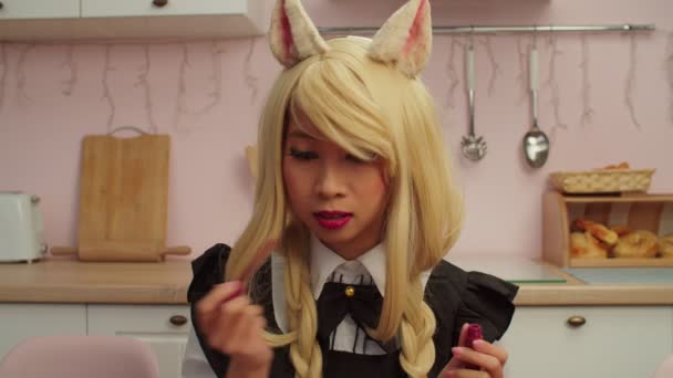 Mooie Aziatische vrouw in vos cosplay kostuum toepassing van rode lippenstift binnen — Stockvideo