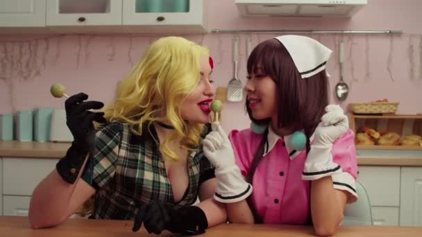 Speelse charmante multi-etnische vrouwen in cosplay kostuums likken lolly 's — Stockvideo
