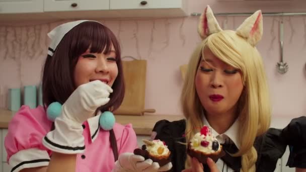 Радісна азіатка в костюмі косметики годує дівчину вишневими цукерками. — стокове відео