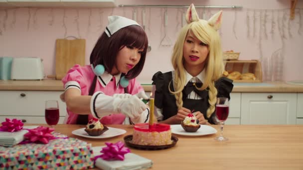 Happy charming Asian women cosplayers lighting candle on birthday cake at home — Stock Video