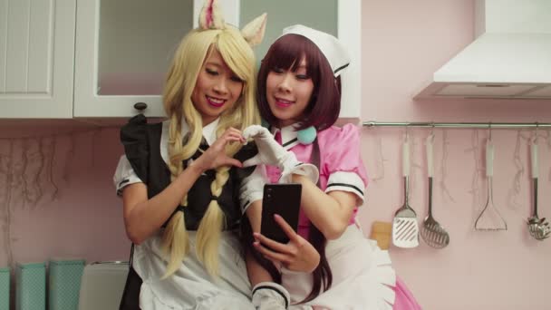 Alegre bonito ásia fêmeas no mangá estilo trajes posando para selfie no telefone — Vídeo de Stock
