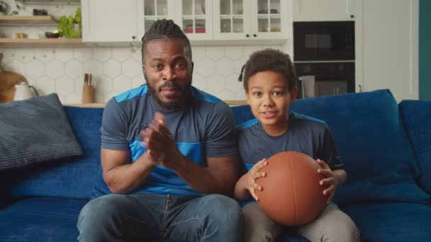 テレビでゲームを見て、勝利を祝う興奮した黒人家族バスケットボールファン — ストック動画