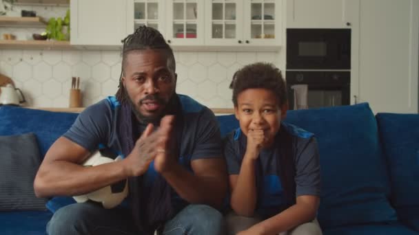 Black family of football fans watching soccer game on tv and celebrating goal — Stock Video