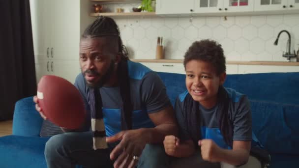 Emocionado pai e filho afro-americano com o futebol comemorando a movimentação de pontuação — Vídeo de Stock