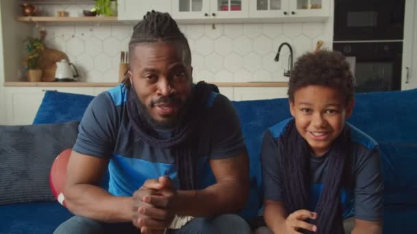 Família negra assistindo futebol americano na TV, comemorando a recepção bem sucedida — Vídeo de Stock