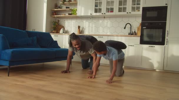 Веселый школьный возраст черный мальчик и отец играют в забавную игру в домашнем хозяйстве — стоковое видео