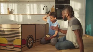 Afrikalı baba ve çocuğu sevmek evde kartondan oyuncak yapmak