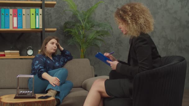 Endişeli kadın klinikte kadın psikoterapist ile terapi seansı yapıyor. — Stok video