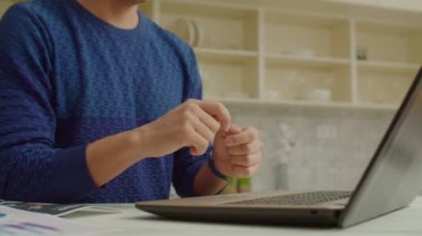 Bilgisayarda video görüşmesi yaparken işaret diliyle konuşan sağır bir adam.