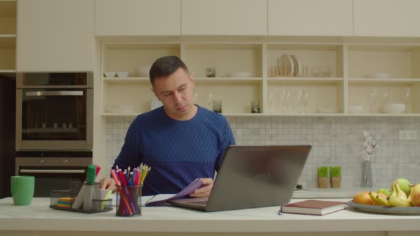 Zaměřený muž s notebookem pracuje na projektu na volné noze z domova — Stock video
