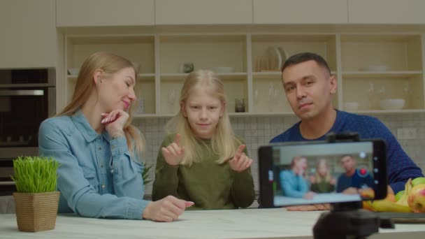 Χαρούμενη σχολική ηλικία κορίτσι με προβλήματα ακοής και γονείς που καταγράφουν βίντεο στο τηλέφωνο — Αρχείο Βίντεο