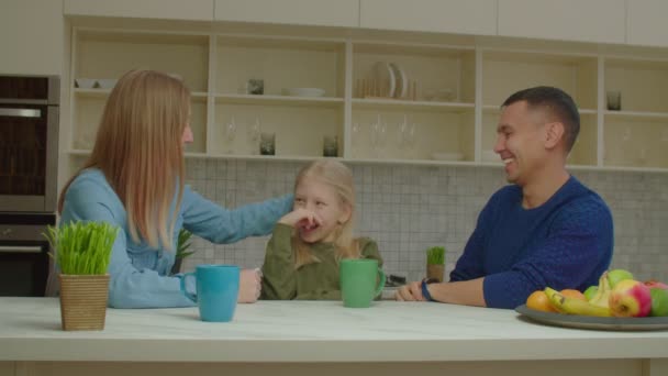 Vreugdevolle slechthorende familie en kind genieten van vrije tijd in de huiselijke keuken — Stockvideo