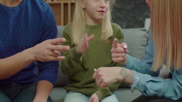 Глухая семья и ребенок с потерей слуха разговаривают с языком жестов в помещении — стоковое видео