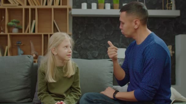 Adorável menina em idade escolar com perda auditiva e ligação pai surdo no sofá — Vídeo de Stock