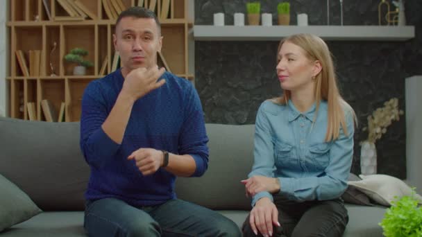 Pozitivní krásný pár se ztrátou sluchu komunikuje s znakovou řečí uvnitř — Stock video