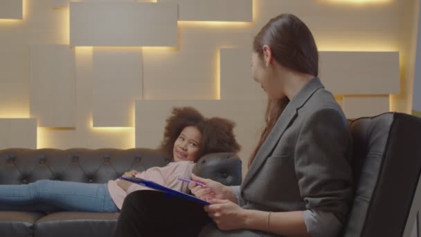 Aziatisch vrouw psychotherapeut counseling zwart klein meisje met geestelijke problemen — Stockvideo