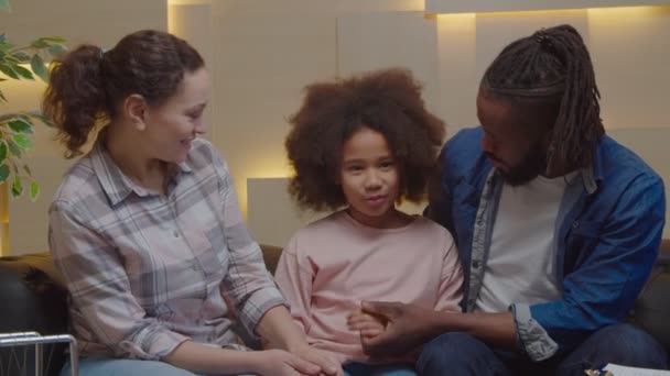 Vrolijke multiculturele familie en meisje omarmen met liefde na therapiesessie — Stockvideo