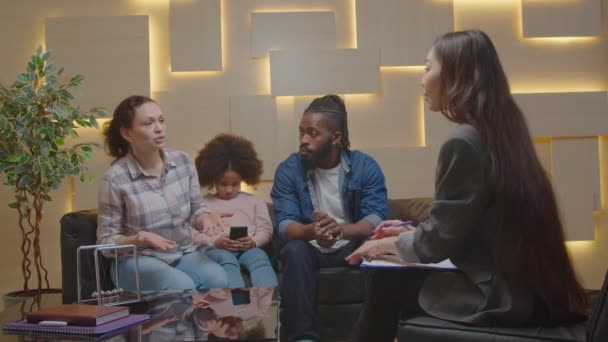 Padres multiétnicos preocupados por el niño adicto al teléfono que visita al psicólogo — Vídeo de stock