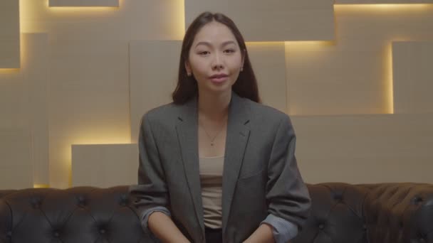 Pewna siebie ładna Azjatka rozmawia przed kamerą podczas rozmowy wideo wewnątrz — Wideo stockowe