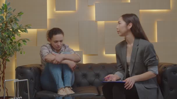 Aziatische vrouw counselor geven psychologische hulp aan depressieve Arabische vrouw indoor — Stockvideo