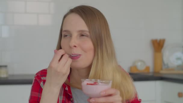 正面迷人的成熟女性的画像 用新鲜的草莓片品尝美味的酸奶 在家中享用健康的早餐时表现出愉快的心情和享受 — 图库视频影像
