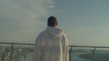 Sportif formda, kapüşonlu Afrikalı sporcu erkek sporcunun yumruklarını sıkmasını, şehir planındaki başarısını ve başarısını gün doğumunda antrenman yaparken kutlamasını..