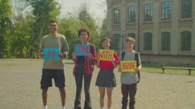 Ukrayna 'nın açık hava harekatına katılıp, Rus işgalinden sonra Ukrayna' daki savaşı durdurmak isteyen, slogan taşıyan, ayakta duran ve slogan taşıyan bir grup genç çok kültürlü insan.