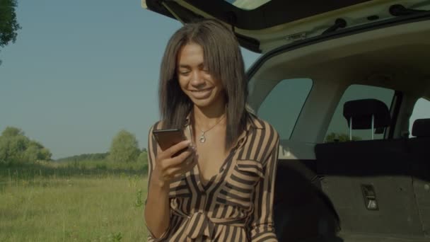 Positive Beautiful Pretty African Female Tourist Sitting Car Trunk Text — Vídeo de Stock