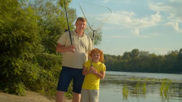 낚싯대를 즐거운 머리의 나이의 아들을 고착륙 여름에 낚시를 연못에 미소를 — 비디오