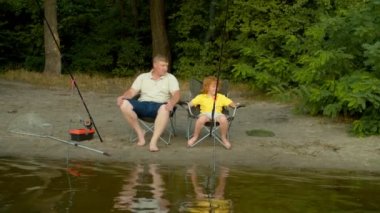 Şirin, kızıl saçlı, okul çağındaki oğlu ve babası nehir kenarındaki seyahat sandalyelerinde oturmuş arkadaşça konuşuyor ve paylaşıyorlar. Bu arada mutlu aile de nehrin kıyısında keyif çatıyor ve balık tutuyor..