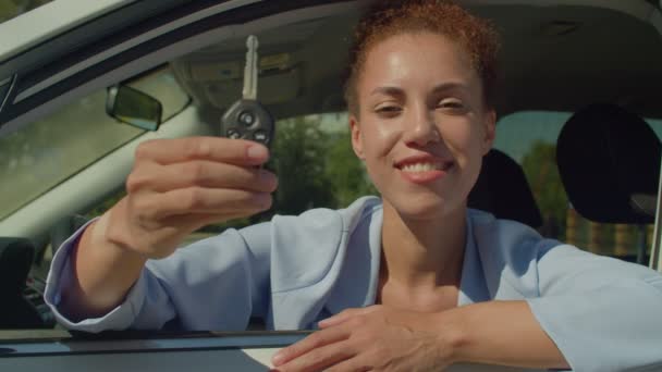 車のディーラーで購入した後 興奮と幸福を表現し 新しい車のキーを示す 車の中で座って楽しい誇りに思って笑顔魅力的な黒人女性ドライバー 車のキー クローズアップに焦点を当てる — ストック動画