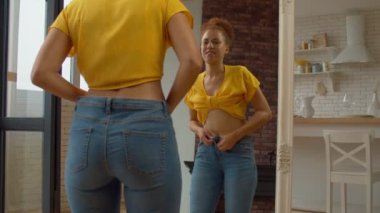 Dar kotları iliklemeye çalışan, evde aynanın karşısında dikilirken umutsuzluk ve hayal kırıklığını ifade eden sinirli, çekici Afrikalı Amerikalı kadın..