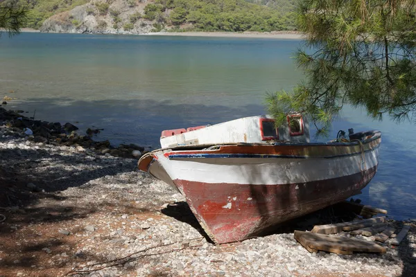 Wooden boat on pebble beach — Stock Photo, Image