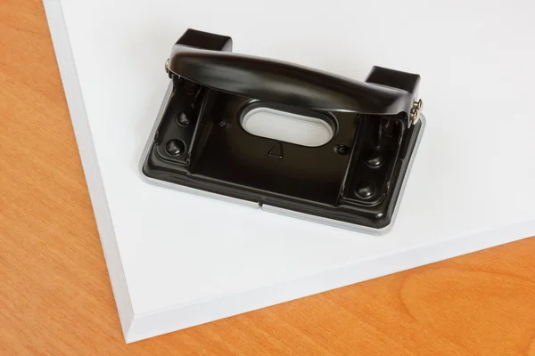 Black office hole punch on a paper stack. — Stock Photo, Image