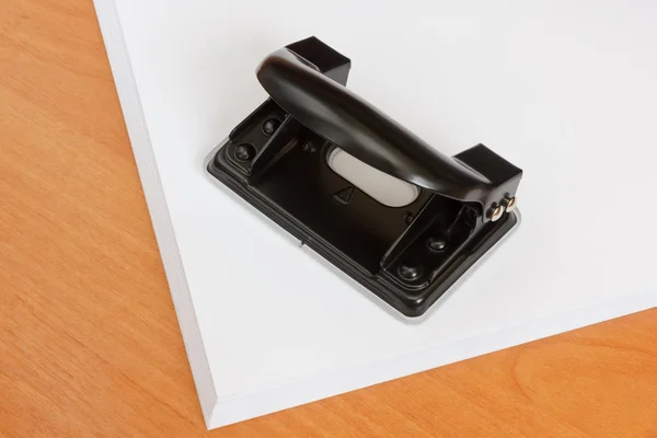 Black office hole punch on a paper stack Royalty Free Stock Photos