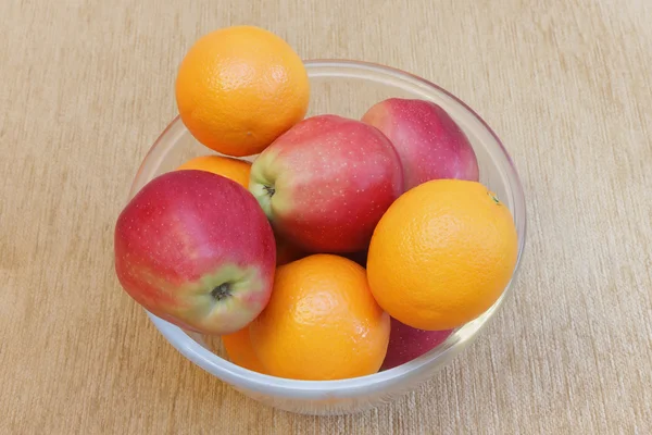 Apples and oranges on glass plate. — Stock Photo, Image