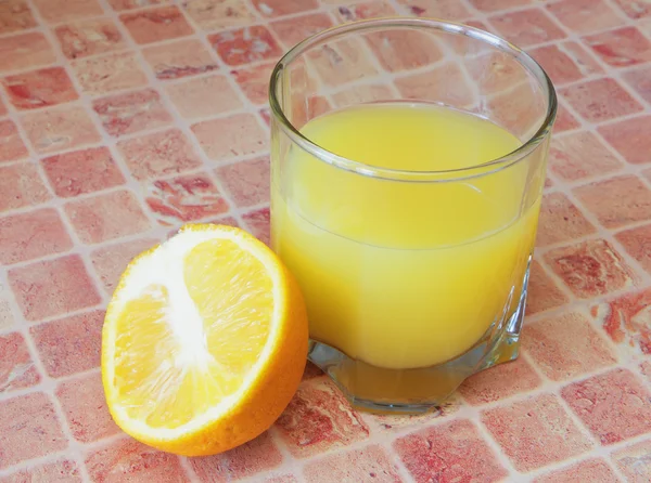 Glass with orange juice and sliced fruit. — Stock Photo, Image