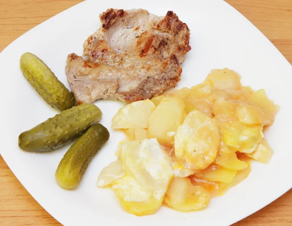 Fried steak, potato and pickles.