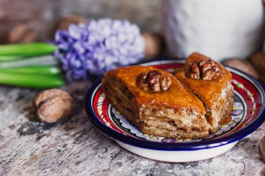 Çeşitli baklavalar. Arka planda kahve fincanı olan dekoratif tabakta Türk ramazanı tatlı bir Arap tatlısı. Orta Doğu gıda baklavası, fındık ve bal şurubu.