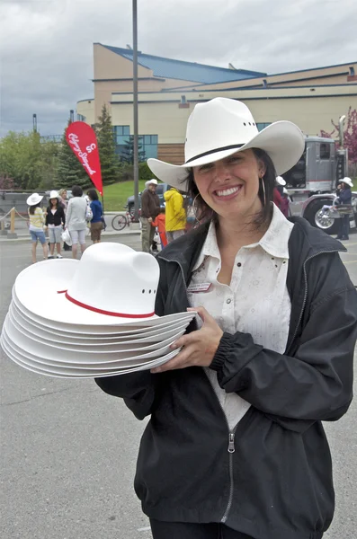 Stampede vrijwilliger uitdeelt hoeden met een glimlach Rechtenvrije Stockfoto's