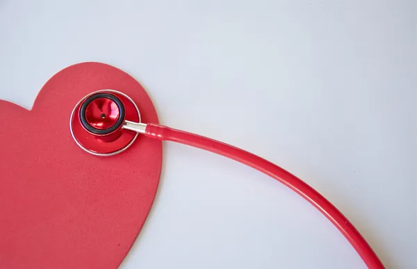 Rotes Stethoskop und Herz Stockfoto