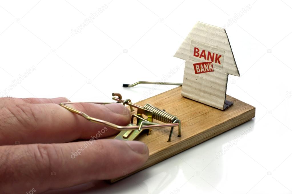 Hand of man caught in mousetrap set by the bank