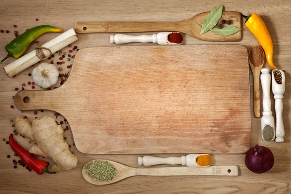 Vegetables and spices border and empty cutting board — Stock Photo, Image