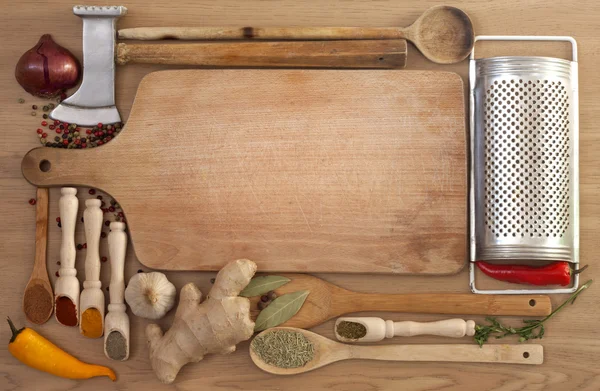 Vegetables and spices border and empty cutting board — Stock Photo, Image