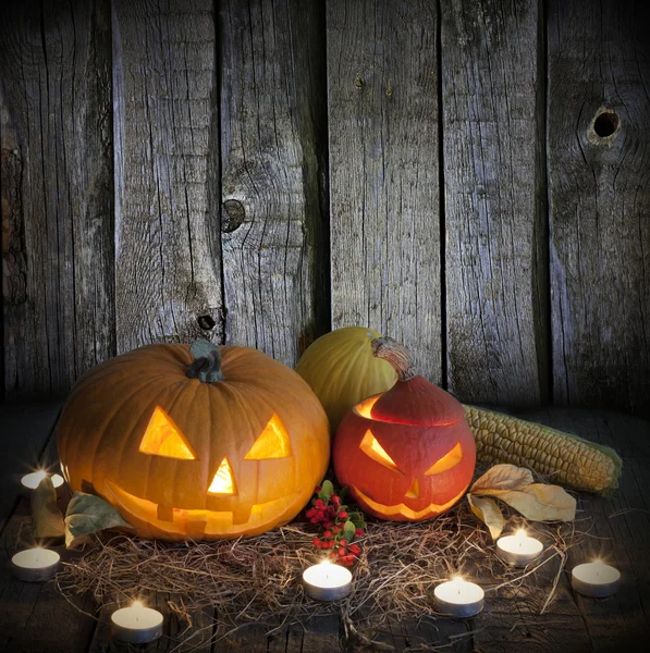 Halloween pompoenen op oude grunge boards en kaarsen — Stockfoto