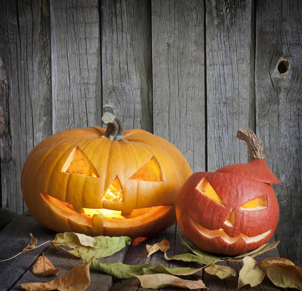 Halloween pumpkins on old grunge boards with leaves background — Stock Photo, Image