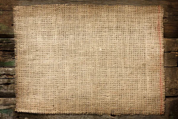 Burlap juta lona vintage fundo em tábuas de madeira — Fotografia de Stock