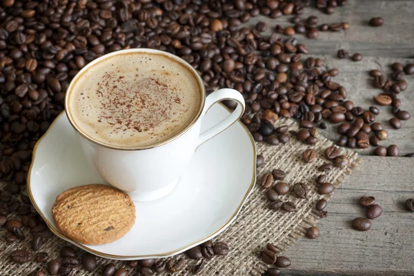 Cappuccino a kávová zrna ročník stále život na prkna — Stock fotografie