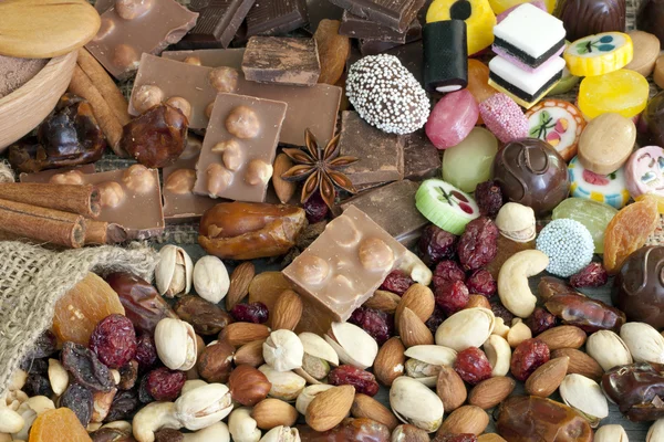 Csokoládé, diófélék, szárított gyümölcsök és candy háttér — Stock Fotó