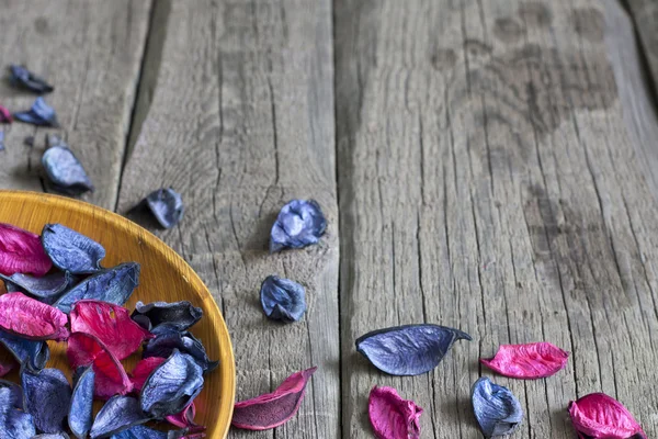 Dried petals in bowl spa concept with wet footprint — Stock Photo, Image